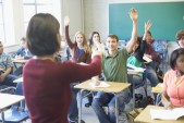 Rear view of a female lecturer standing in front of a classroom