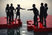 Merger of two teams on a jigsaw puzzle at sunset.