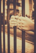 Child's hands holding a iron rods