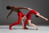 Couple of ballet dancers posing over gray background